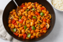 Zoetzure kip met paprika, champignons en ananas in een wok