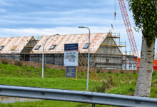 Bouwproject in Zwolle met woningen in aanbouw, steigers en een bouwkraan.