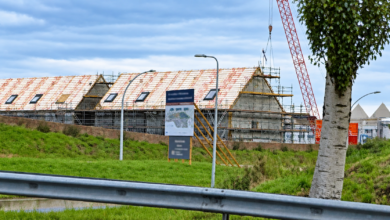 Bouwproject in Zwolle met woningen in aanbouw, steigers en een bouwkraan.