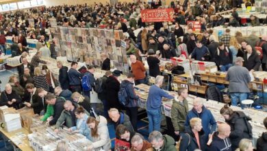 Bezoekers zoeken naar lp’s en vinylplaten tijdens een grote platenbeurs