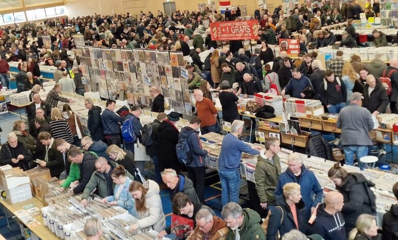 Bezoekers zoeken naar lp’s en vinylplaten tijdens een grote platenbeurs