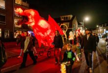 Deelnemers aan de Zwolse Lichtparade met verlichte kunstwerken tijdens Sint Maarten in Zwolle