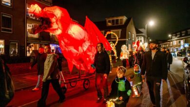 Deelnemers aan de Zwolse Lichtparade met verlichte kunstwerken tijdens Sint Maarten in Zwolle