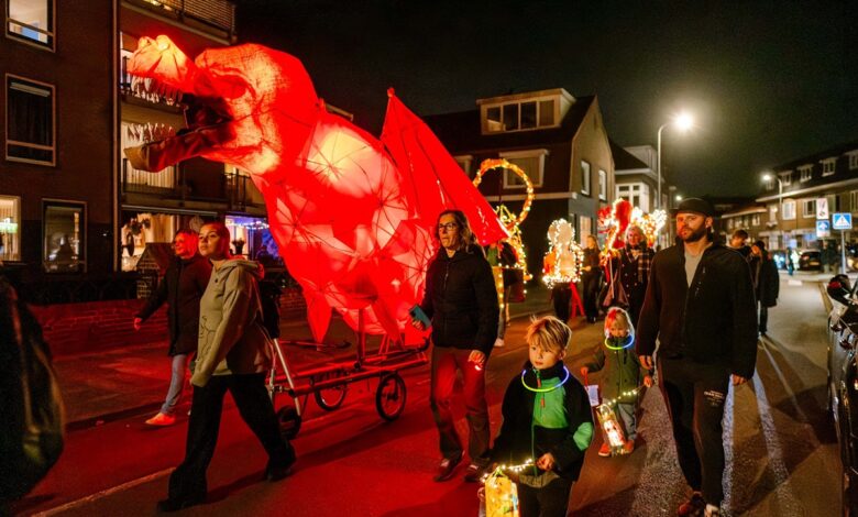 Deelnemers aan de Zwolse Lichtparade met verlichte kunstwerken tijdens Sint Maarten in Zwolle